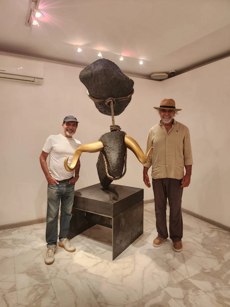 Two men flank the bull in the hall.