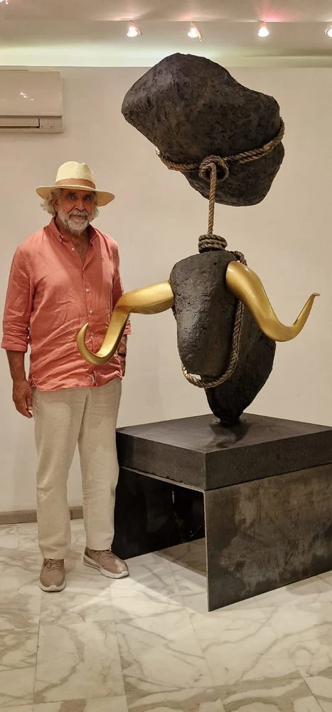 A man in a pink shirt beside the bull.