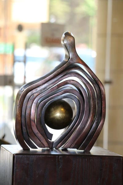 Curving layers of metal around a sphere.