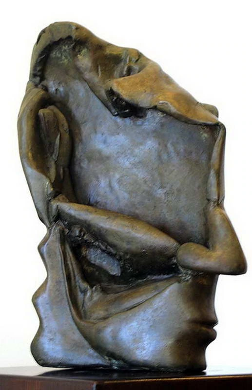 Bronze profile with a broad recessed forehead and a horizontal fold crossing the eye area.
