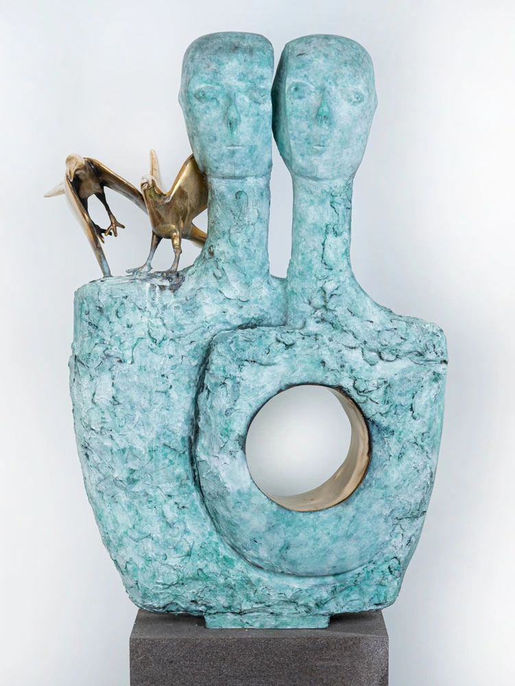 A two-headed form with a turquoise surface, a circular opening and birds at the shoulder.