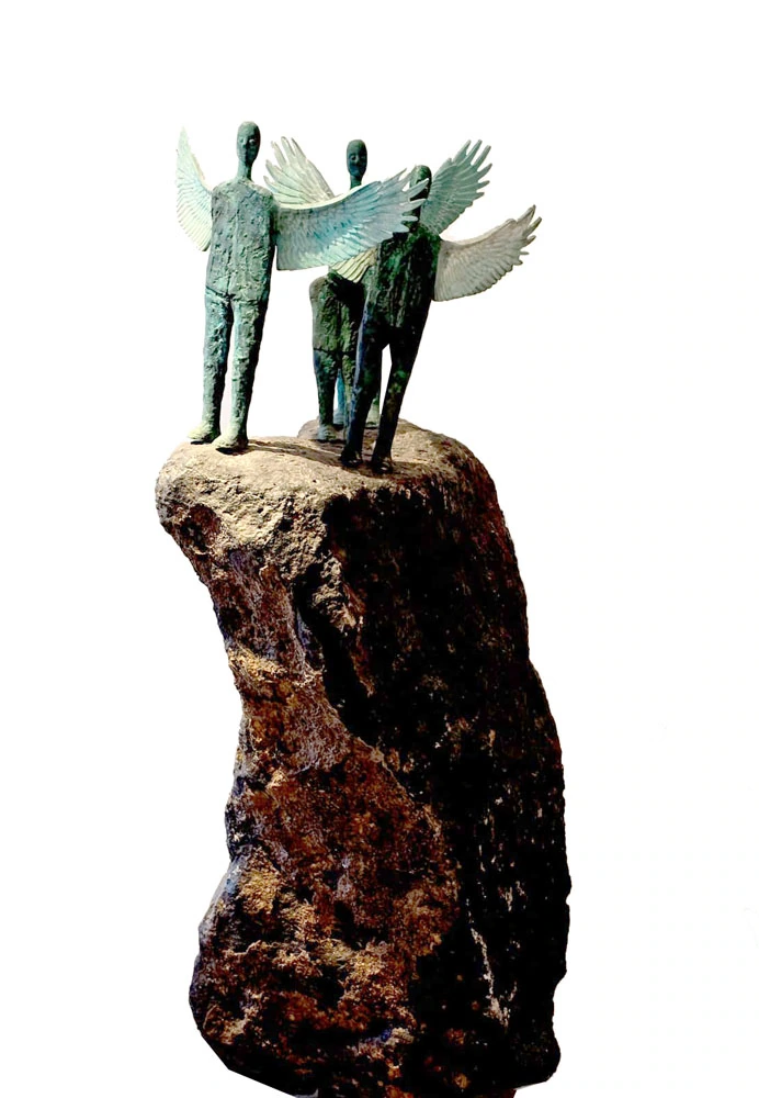 Three winged figures on a tall rough stone base, viewed from the front against white.