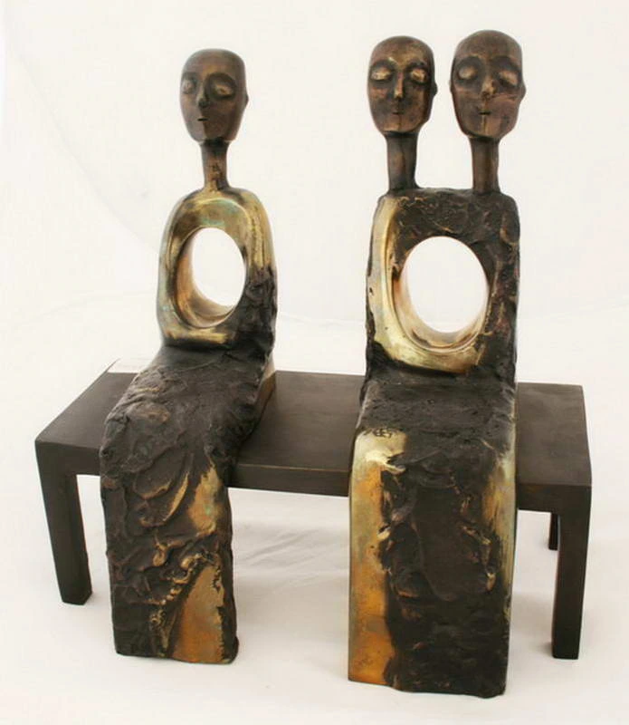 Two seated figures with three heads and two openings in their torsos.
