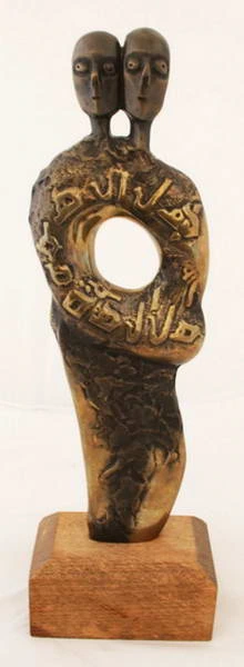 Two heads above a circular opening surrounded by raised lettering.