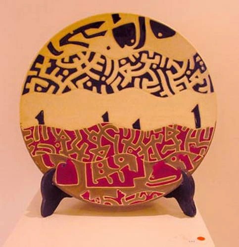 A plate divided between a yellow field of black interlace and a red field of pale animal figures.