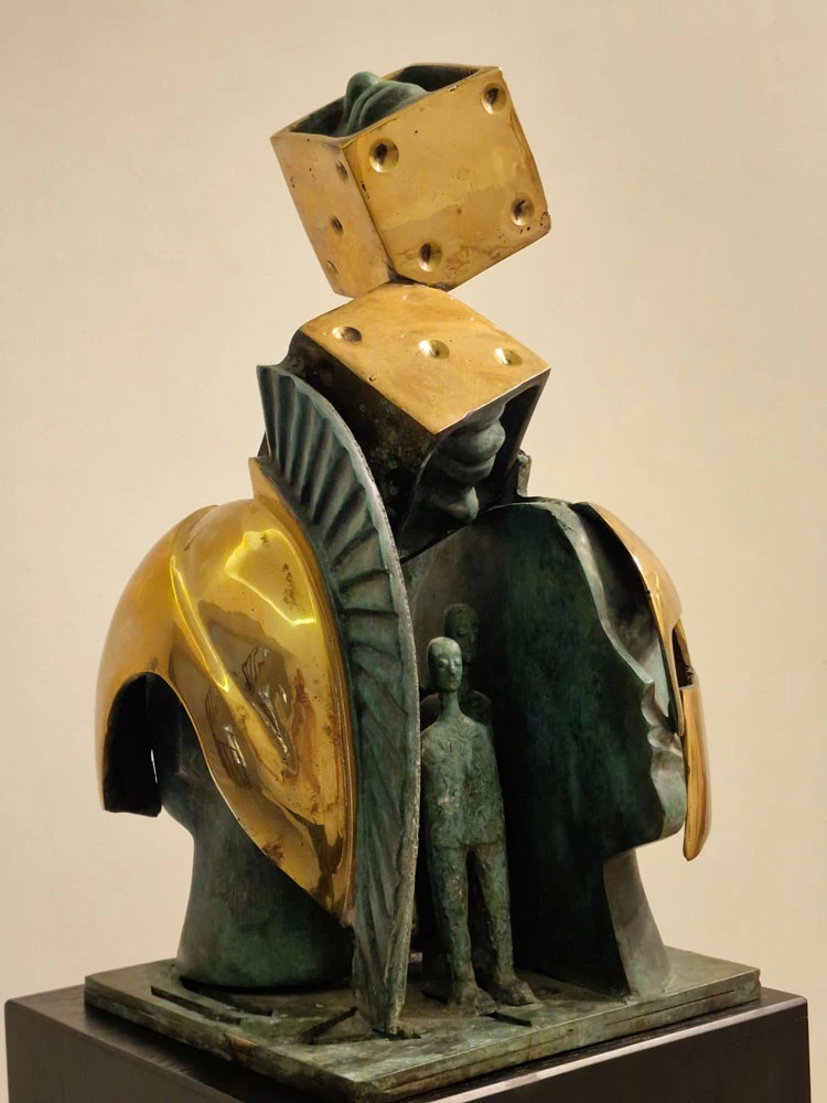 Helmeted heads, dice and a small standing figure; the open side of the work.