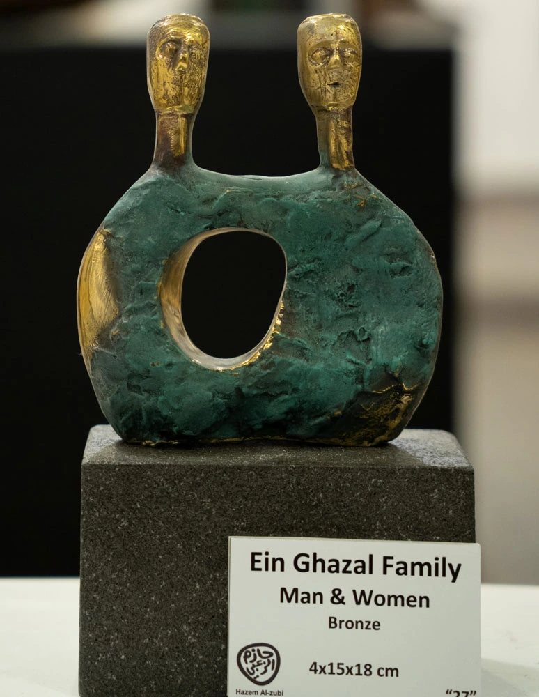 A two-headed form with one opening, photographed with its exhibition label.