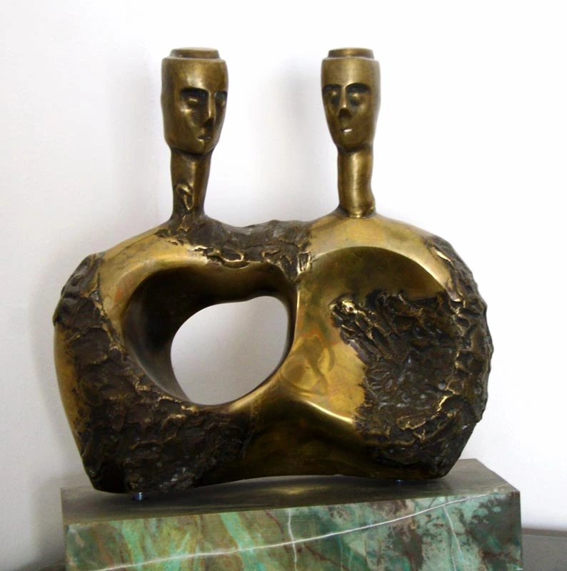 A joined two-headed form with a large opening, on a veined stone base.