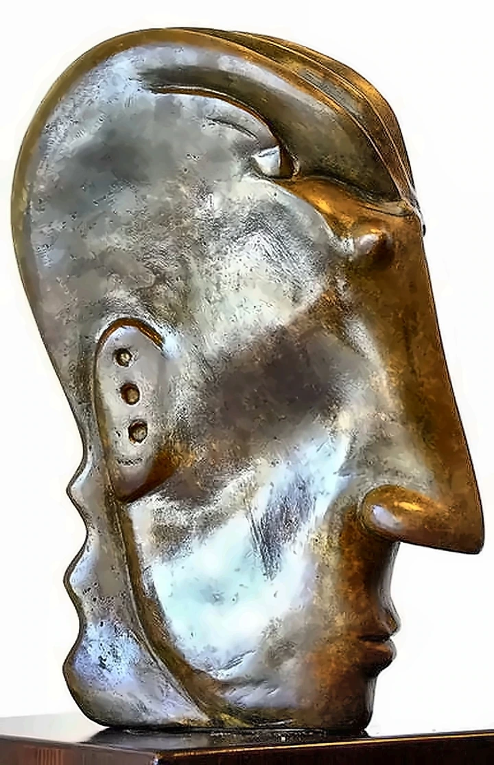 A large smooth bronze head in profile, the surface polished, a row of small holes cut into the cheek.
