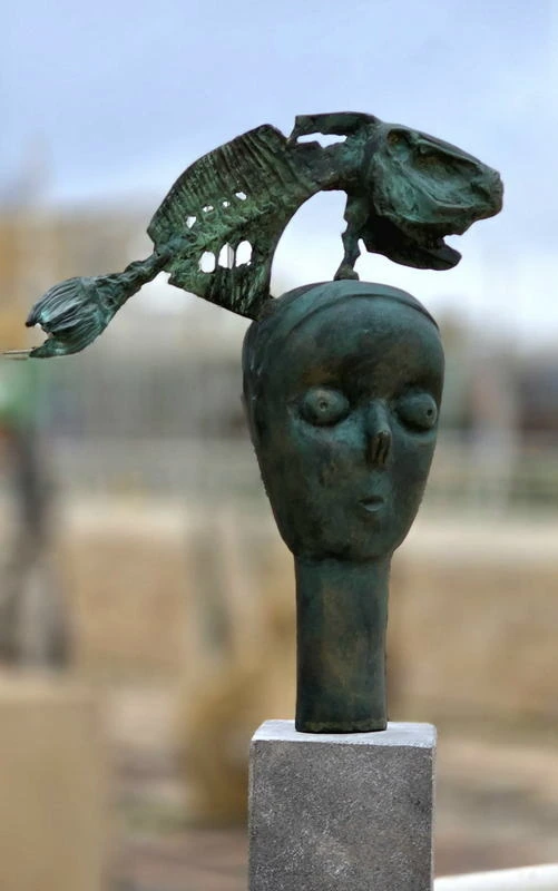 The same work from the front, the gilded birds spilling forward out of the cupped hands.