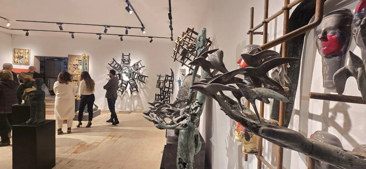 Birds in bronze in the foreground; visitors and wall-mounted works beyond.
