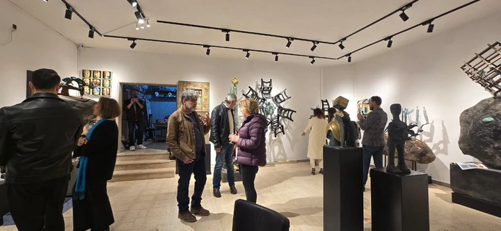 A wider view of visitors and sculptures across the hall.