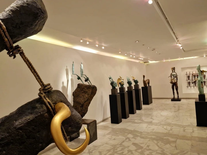 From the suspended stone and gilded horn towards the row of heads.