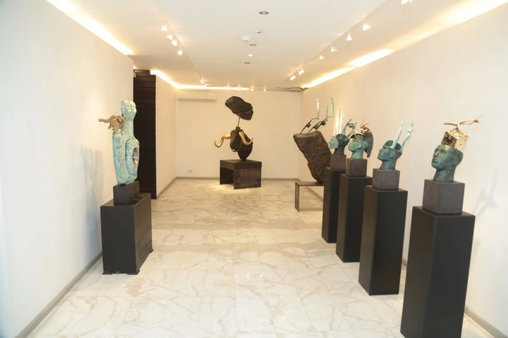 A row of sculpted heads facing the works at the end of the room.