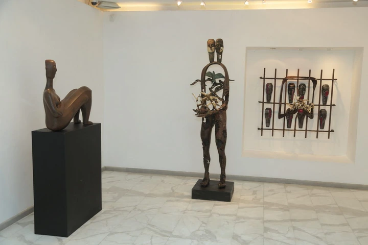 A seated figure, the standing twin figure and the grille of masks.