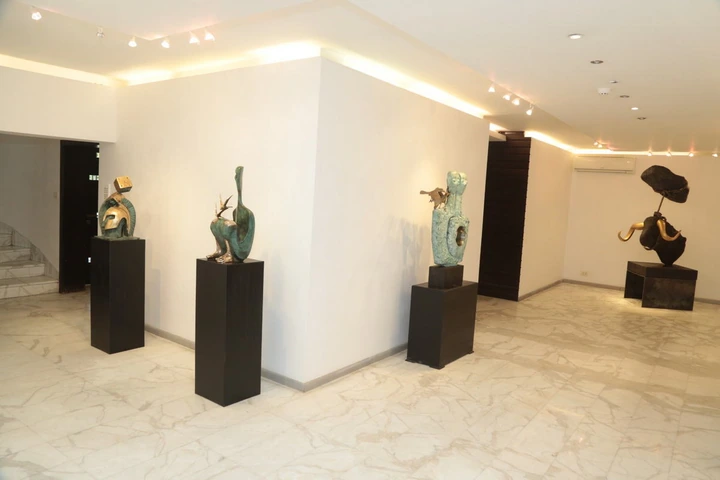 Three sculptures around the corner of the room, with the suspended stone beyond.