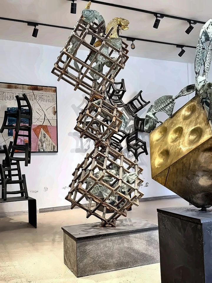 Lattice towers in iron and bronze with birds enclosed inside them.