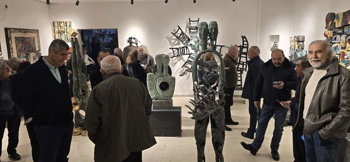 Guests gathered around the bird-bearer bronze in the hall.