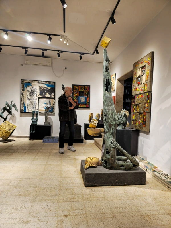 A visitor beside the upturned figure with the gilded die.