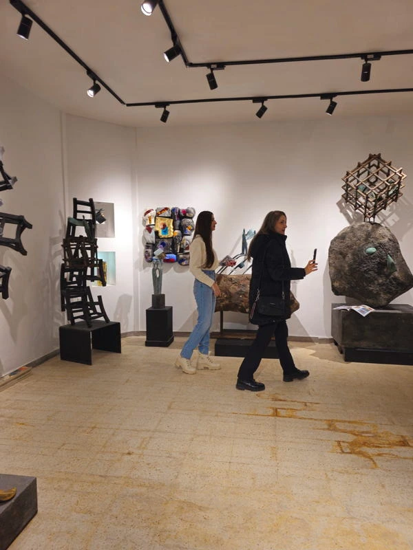 Two visitors walking past the works.