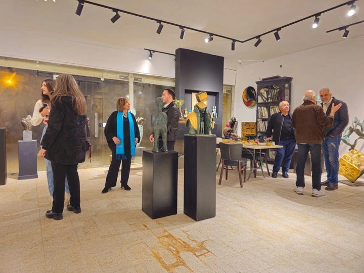 Visitors in the hall by the black plinths.