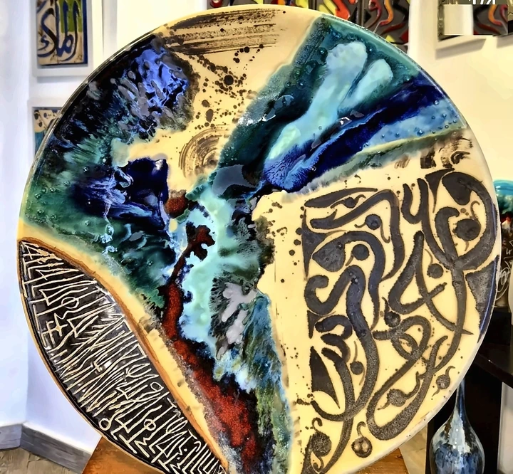 A large plate in cobalt and oxblood glaze with incised calligraphy.