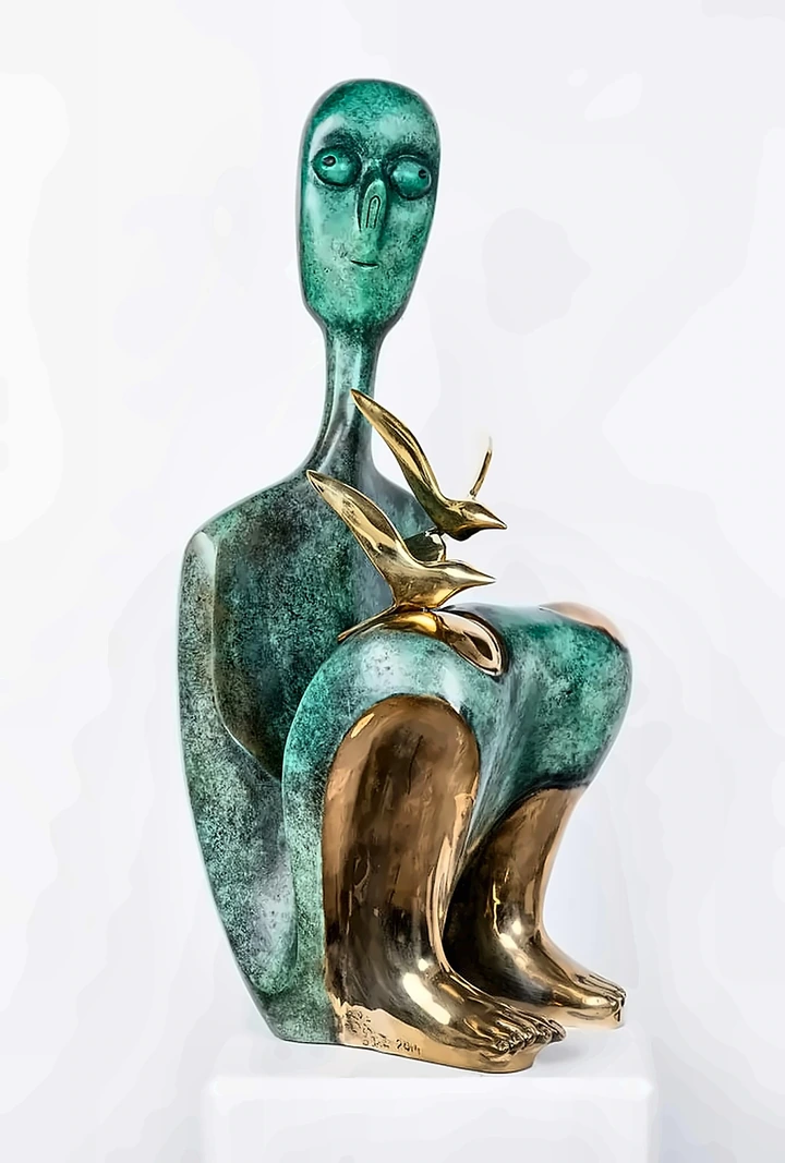 A seated bronze figure in green patina with polished golden feet and shins, two burnished birds resting on the knee.