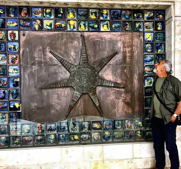 A large wall of ceramic tiles with a bronze star form at its centre.