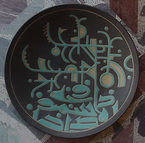 A near-black plate covered edge to edge in pale green incised script and circular signs.