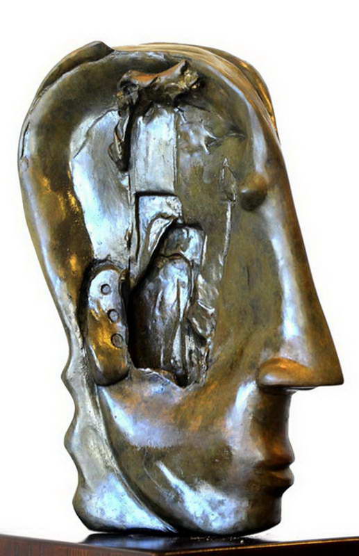 Bronze head in profile with an open recess revealing folded, layered forms inside the face.