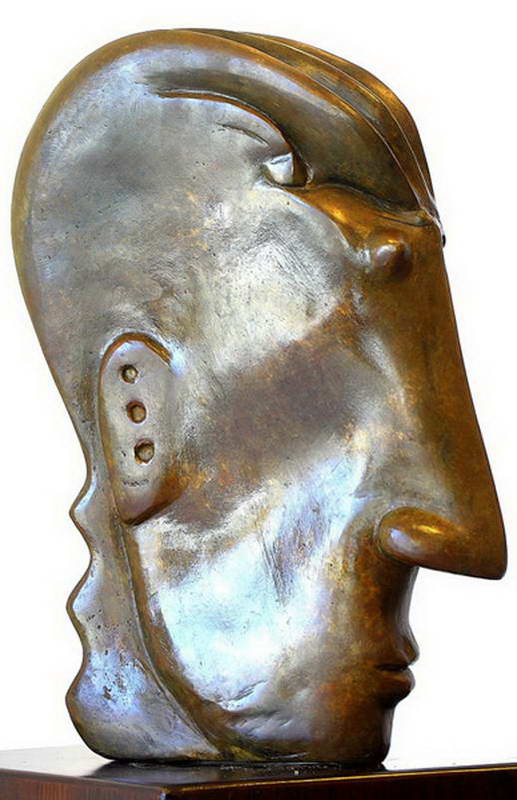A large smooth bronze head in profile, the surface polished, a row of small holes cut into the cheek.