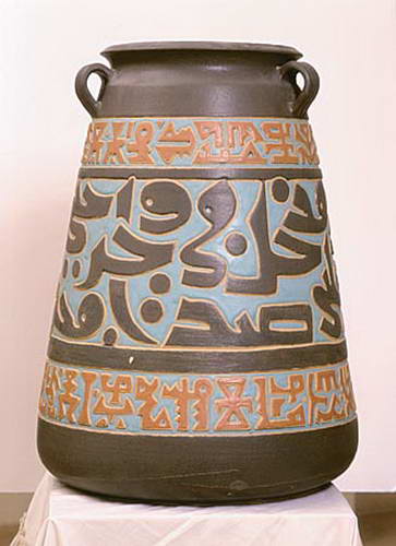 A large dark two-handled jar with three bands of incised script, the middle band pale blue, the outer bands terracotta.